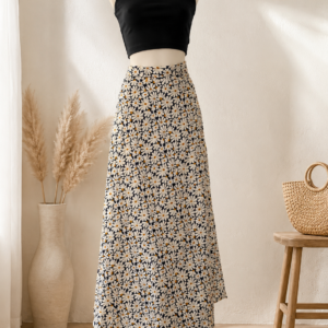 Jupe longue portefeuille Nolïa en viscose à motifs marguerites, portée avec un top noir.